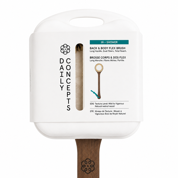 A Daily Concepts in-shower back and body flex brush with a white plastic handle and a natural wood bristle head, shown against a plain white background.