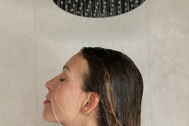 A face under running water, eyes closed.