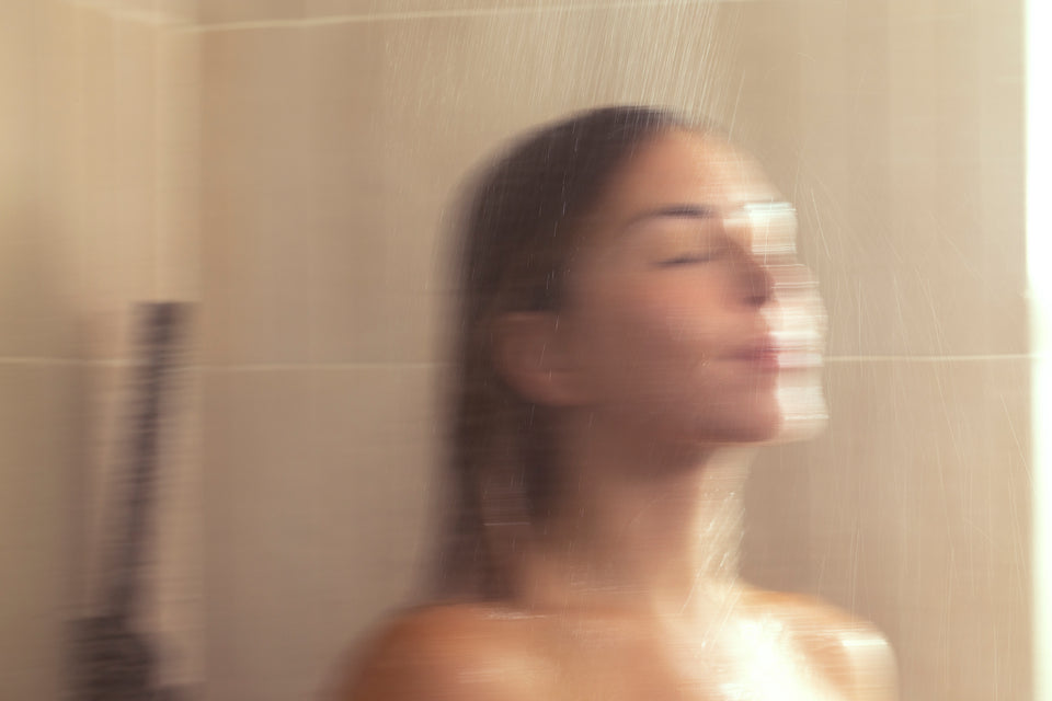A blurred figure seen through steamed glass.
