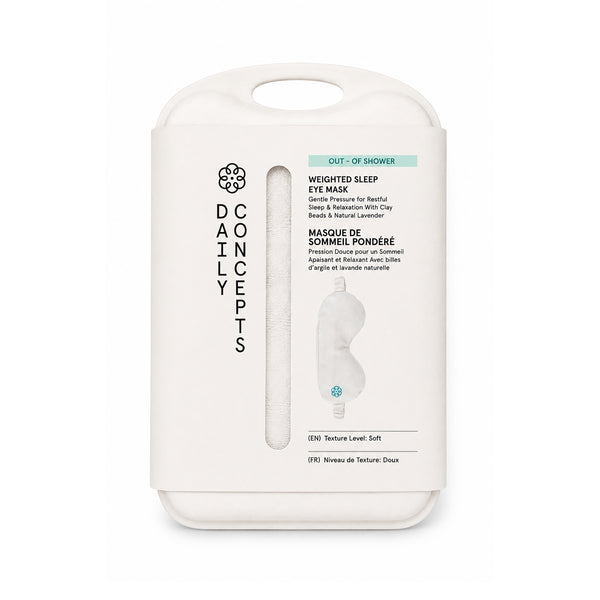 A white cardboard retail package for a Concepts Daily Weighted Sleep Eye Mask, shown on a clean white background. The package features a handle, a vertical window displaying the eye mask, and text indicating it is an out-of-shower weighted sleep eye mask with beads and natural lavender.
